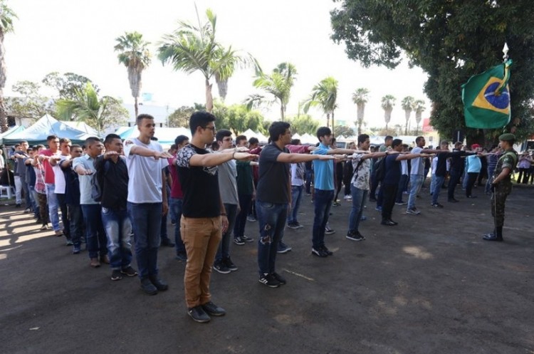 Jovens dispensados do serviço militar fazem juramento à bandeira durante cerimônia